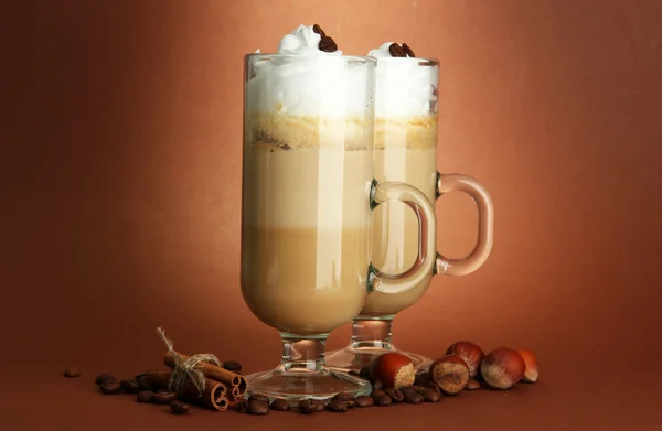 Μυρωδάτο καφέ latte σε γυαλιά κύπελλα με μπαχαρικά, σε καφέ φόντο — Φωτογραφία Αρχείου