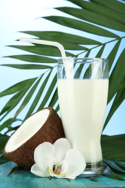 Coco con vaso de leche, sobre fondo azul —  Fotos de Stock