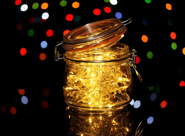 Luces de Navidad en botella de vidrio sobre fondo de luces borrosas —  Fotos de Stock