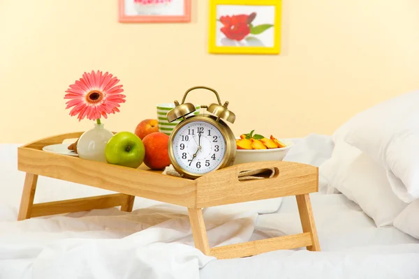 Wooden tray with light breakfast on bed — Stock Photo, Image