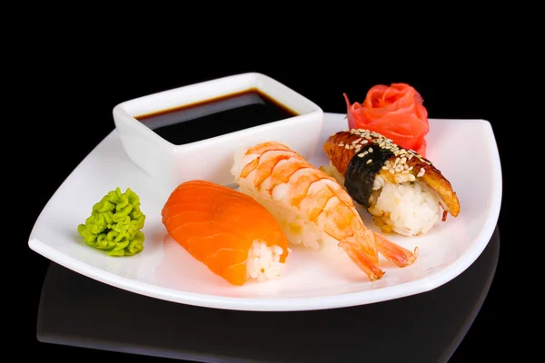 Köstliches Sushi auf einem Teller isoliert auf schwarz serviert — Stockfoto