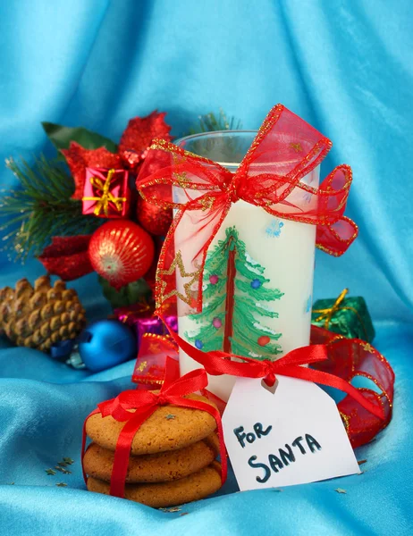 Cookies for Santa: Conceptual image of ginger cookies, milk and christmas decoration on blue background — Stock Photo, Image