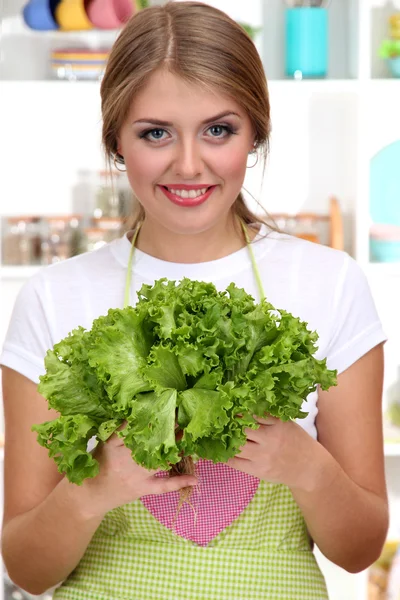 Uma jovem na cozinha com ervas nas mãos — Fotografia de Stock