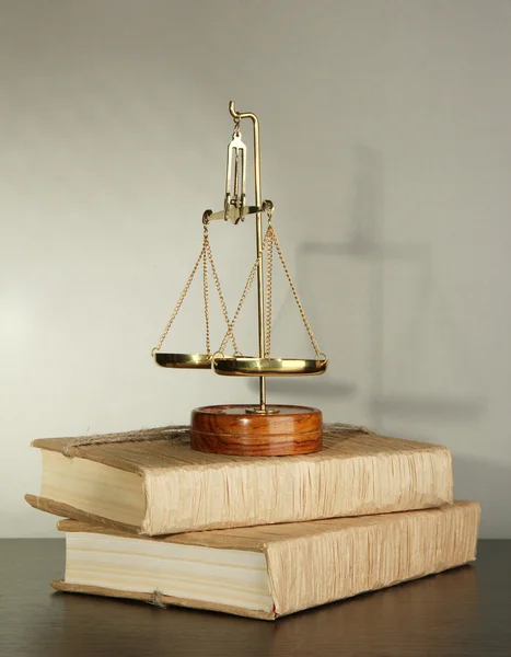 Gold scales of justice and books on grey background — Stock Photo, Image