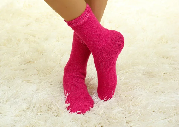 Female legs in colorful socks on white carpet background — Stock Photo, Image