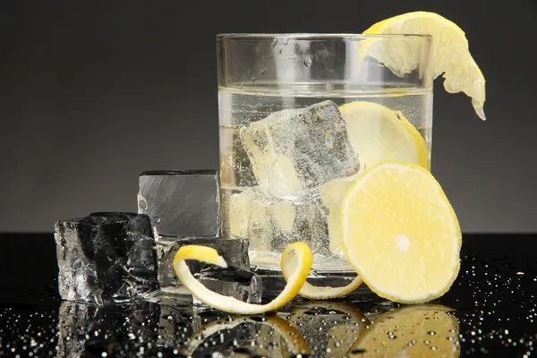 Cubes de glace en verre avec citron isolé sur noir — Photo