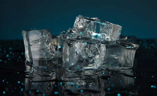 Cubos de gelo no fundo azul escuro — Fotografia de Stock