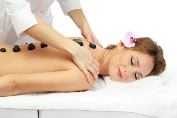 Hermosa mujer en el salón de spa con piedras de spa recibiendo masaje, aislado en blanco —  Fotos de Stock