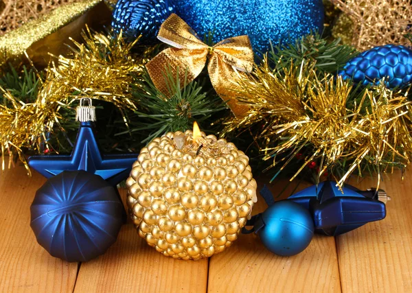 Christmas composition with candles and decorations in blue and gold colors on wooden background — Stock Photo, Image