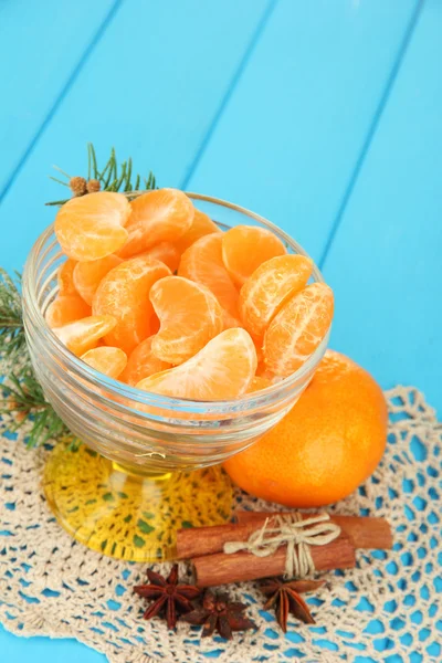 Sabrosas rebanadas de mandarina en tazón de vidrio sobre fondo azul —  Fotos de Stock