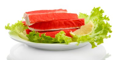 Yengeç sopalarla marul yaprakları ve plaka üzerinde beyaz izole limon