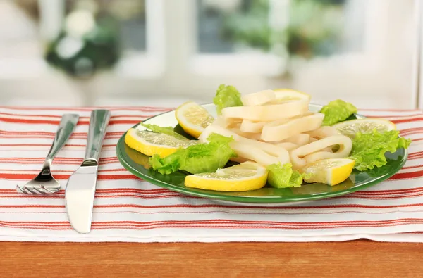 Gekochte Tintenfischringe auf Salat mit Zitrone auf dem Teller Nahaufnahme — Stockfoto