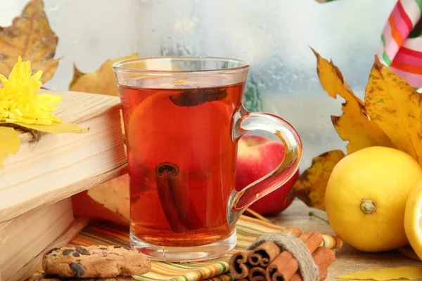 Чашка горячего чая и осенние листья, на деревянном столе — стоковое фото