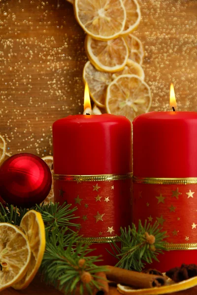 Twee kaarsen en kerstversiering, op gouden achtergrond — Stockfoto