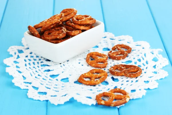 Tasty pretzels in white bowl on wooden table close-up — Stock Photo, Image