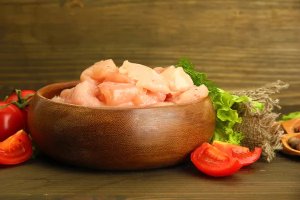 Rohes Hühnerfleisch in Schüssel, auf Holzgrund — Stockfoto