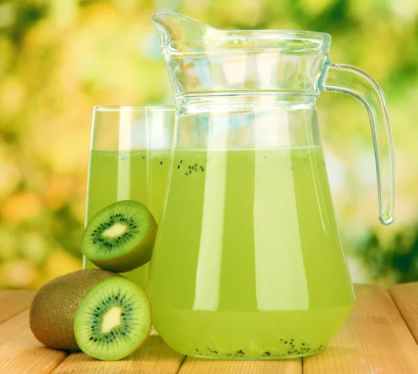 Volles Glas mit Kiwi-Saft und Kiwi auf Holztisch im Freien — Stockfoto