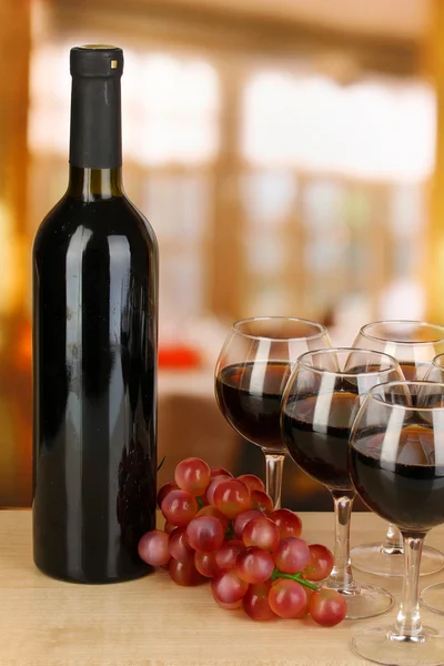 Red wine in glass and bottle on room background — Stock Photo, Image