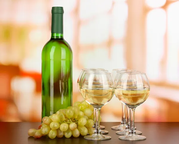Witte wijn in glas en fles op kamer achtergrond — Stockfoto