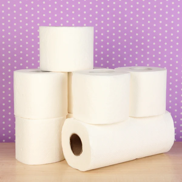Rolls of toilet paper on purple with dots background — Stock Photo, Image