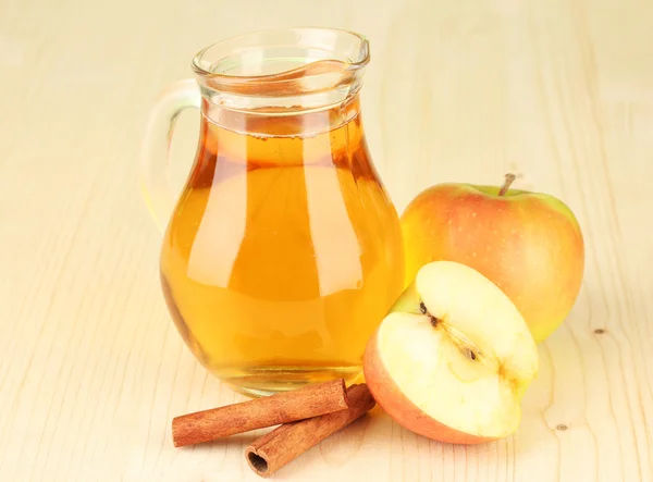 Pleine cruche de jus de pomme et de pomme sur fond en bois — Photo