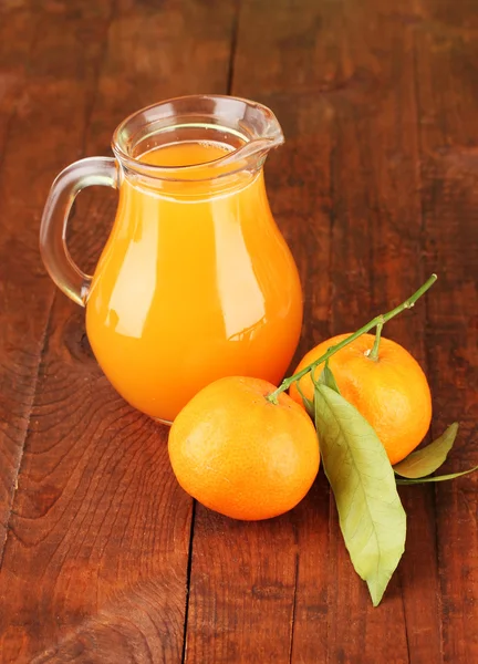Full jug of tangerine juice, on wooden background — Stock Photo, Image