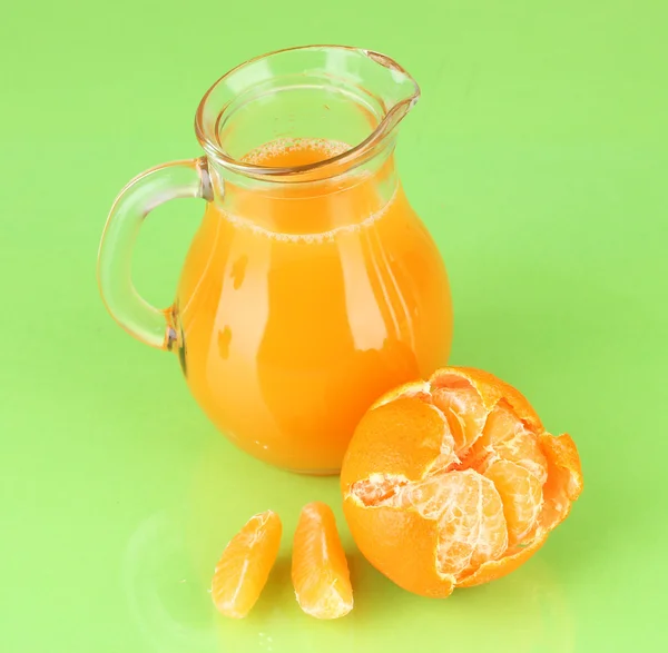 Jarro cheio de suco de tangerina, em fundo de cor de madeira — Fotografia de Stock