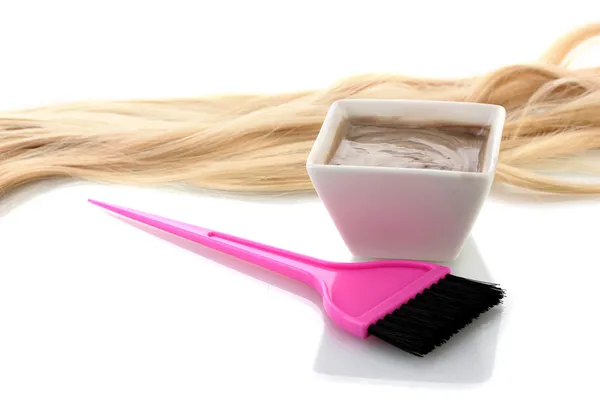 Tigela com tintura de cabelo e escova rosa no fundo branco close-up — Fotografia de Stock