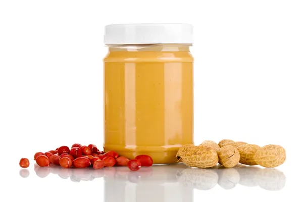 Delicious peanut butter in jar of peanut near isolated on white — Stock Photo, Image