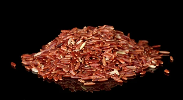 Red rice isolated on black — Stock Photo, Image