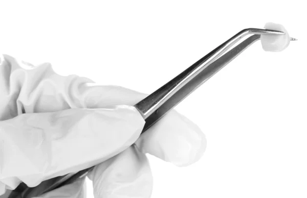 白で隔離される義歯とピンセットを保持している医療用手袋で手を歯科医 — ストック写真