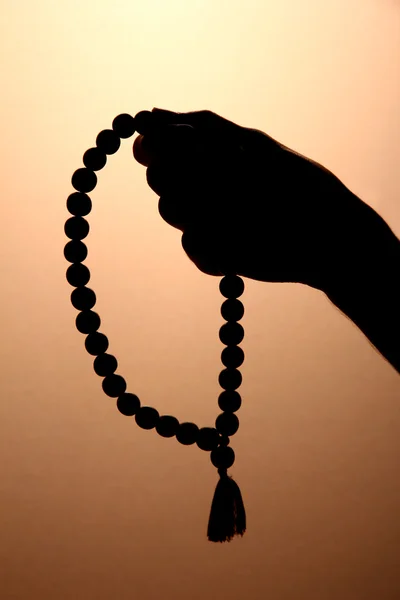 Male hand with rosary, on brown background — Stock Photo, Image