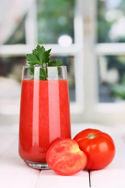 Copo de suco de tomate na mesa de madeira, no fundo da janela — Fotografia de Stock