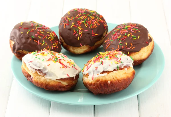 Smakelijke donuts op kleurplaat op lichte houten achtergrond — Stockfoto