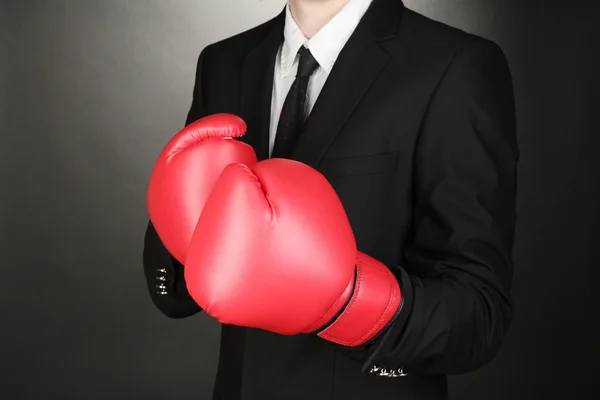 Businessman in boxing gloves on grey background — Stock Photo, Image