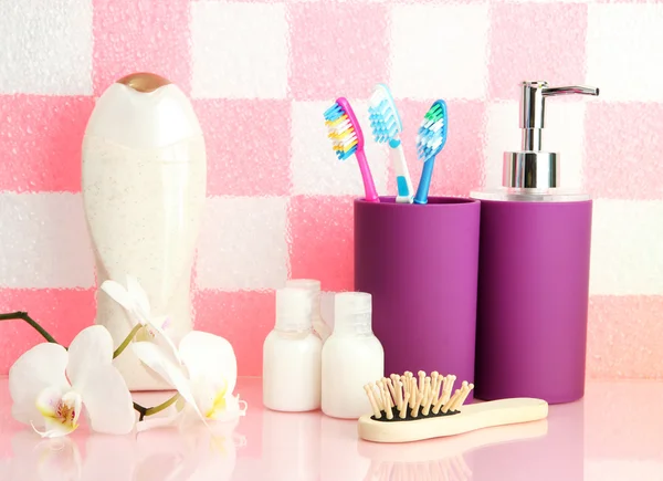 Bath accessories on shelf in bathroom on pink tile wall background — Stock Photo, Image