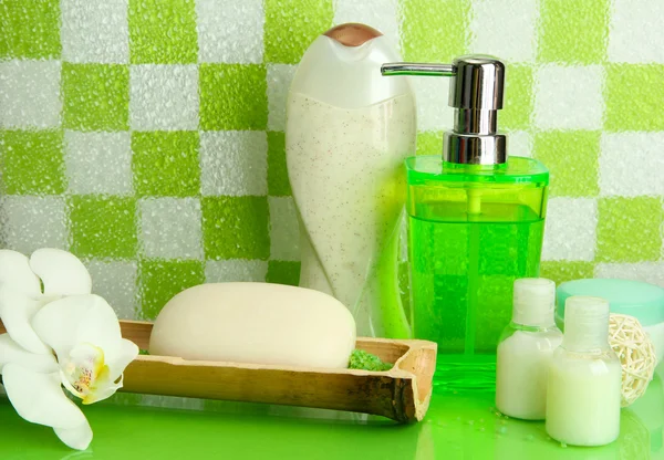 Bath accessories on shelf in bathroom on green tile wall background — Stock Photo, Image