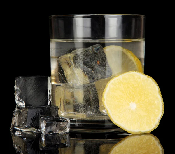 Cubos de hielo en vidrio con limón aislado en negro —  Fotos de Stock