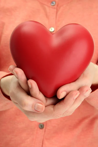 Corazón rojo en las manos de la mujer, de cerca — Foto de Stock