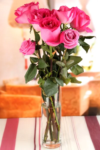 Schöne rosa Rosen in der Vase auf dem Tisch auf dem Hintergrund des Zimmers — Stockfoto