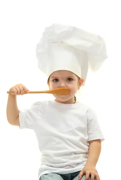 Маленькая девочка доктор в шляпе шеф-повара с ложкой, изолированные на белом — стоковое фото