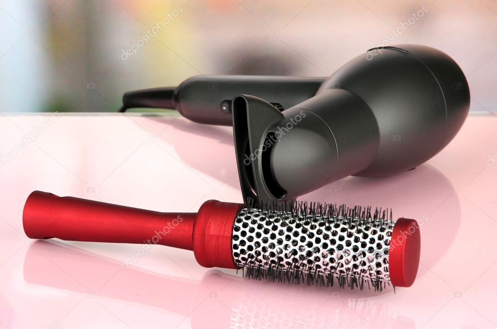 hair dryer and comb brush, on table in beauty salon