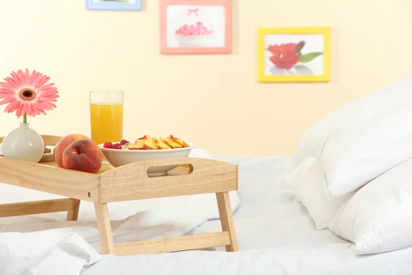 Wooden tray with light breakfast on bed — Stock Photo, Image