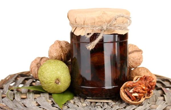 Jam-jar of walnuts on wicker mat — Stock Photo, Image