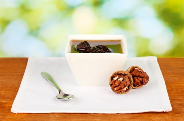 La confitura, las nueces en la escudilla sobre la mesa sobre el fondo verde — Foto de Stock