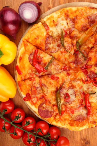 Вкусная пицца пепперони с овощами на деревянном фоне — стоковое фото