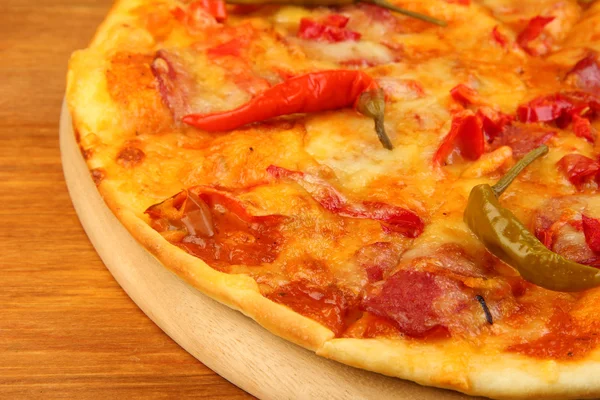 Pizza de pepperoni saborosa em tábua de madeira em fundo de madeira — Fotografia de Stock