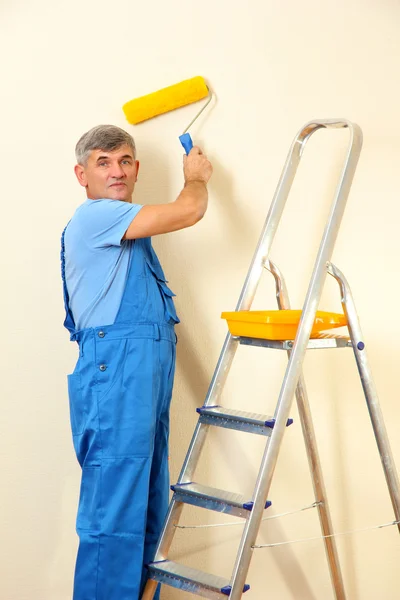 Pintor masculino pinta la pared en la habitación de cerca —  Fotos de Stock