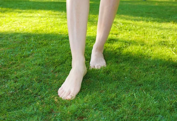 Pernas andando no gramado verde — Fotografia de Stock