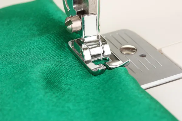 Zbliżenie części pracy maszyn do szycia z zielonym suknem — Zdjęcie stockowe